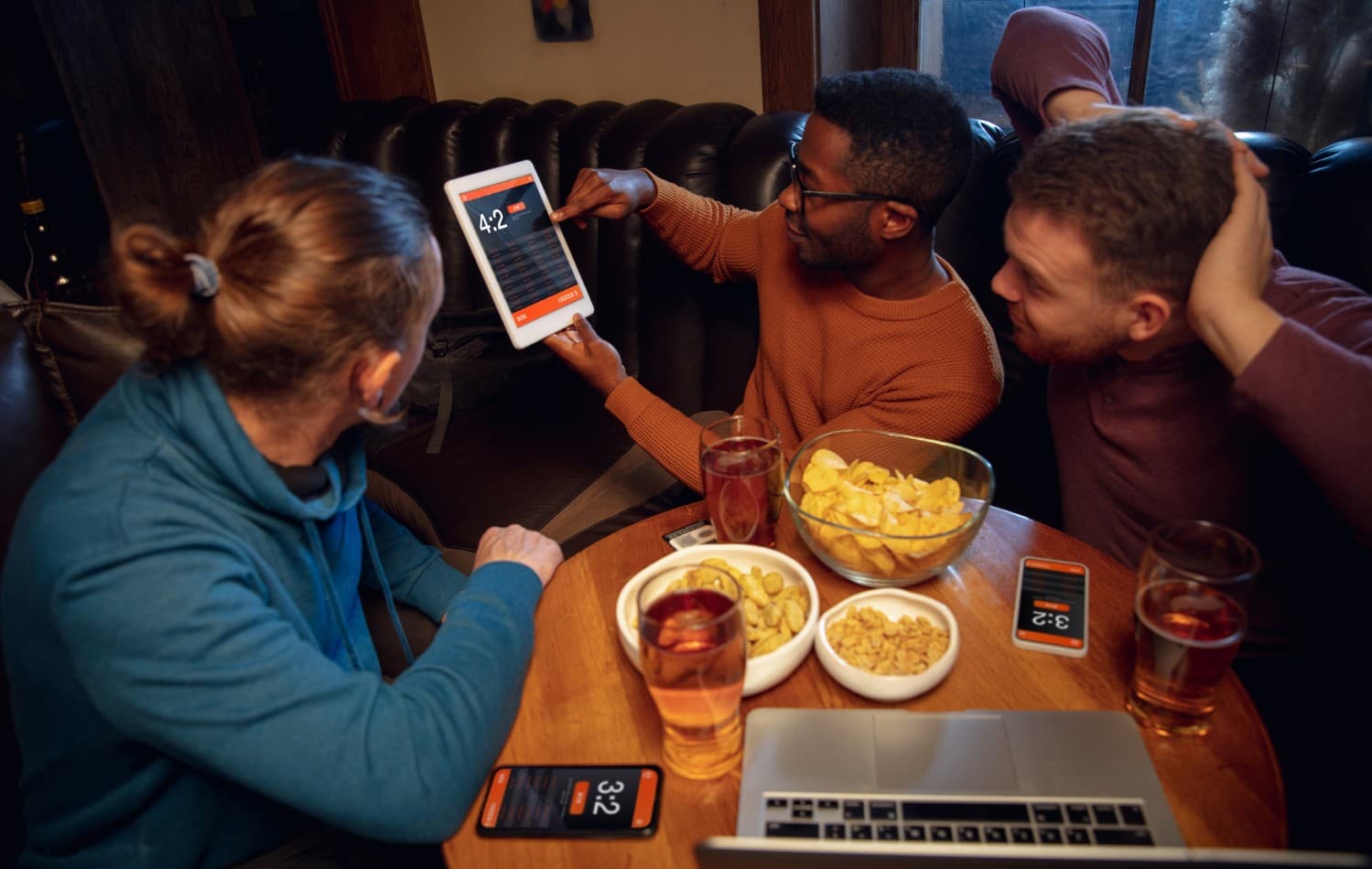 3 co-workers looking at some statistics from a tablet.